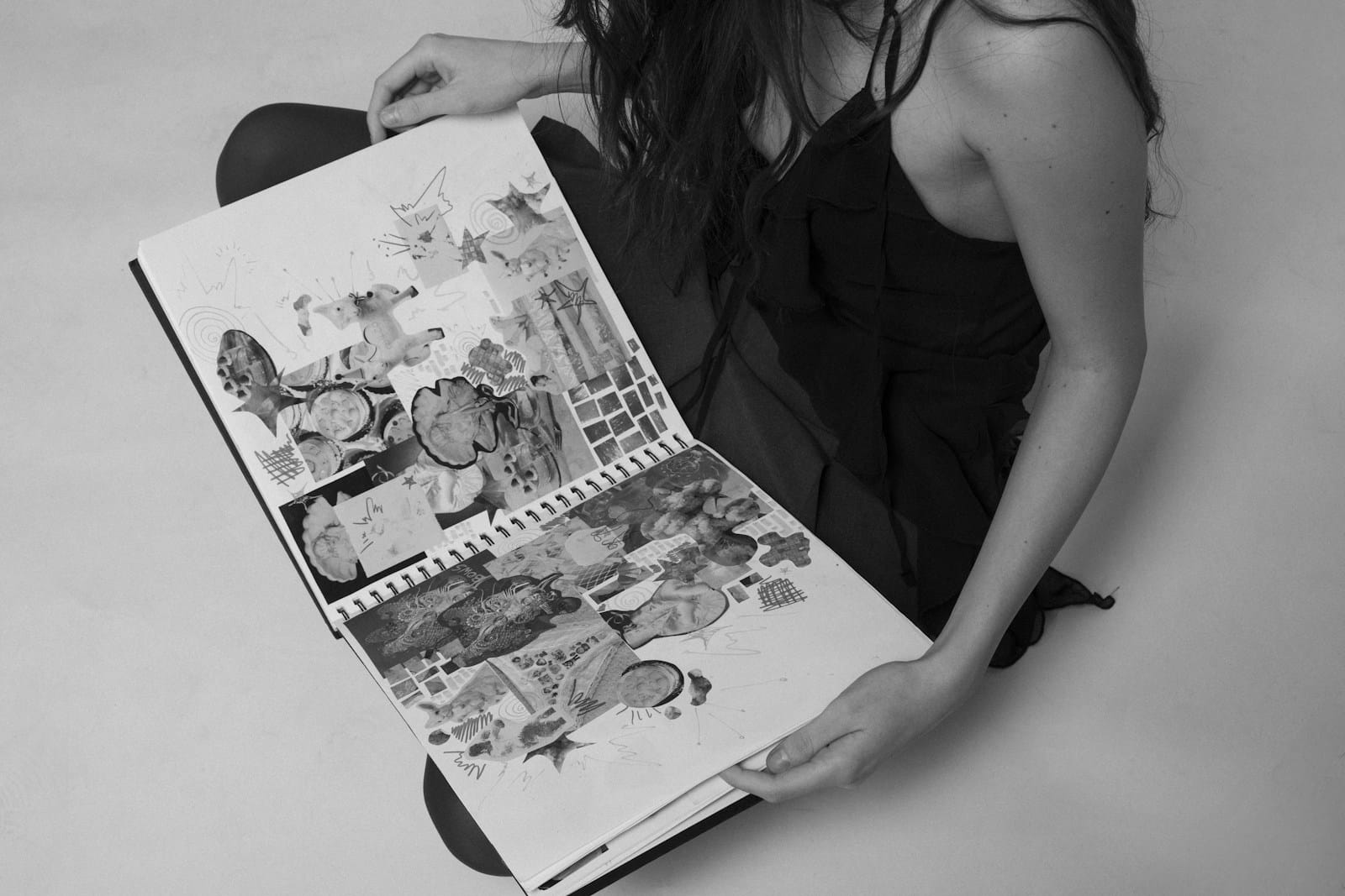 A woman sitting on the floor holding a magazine